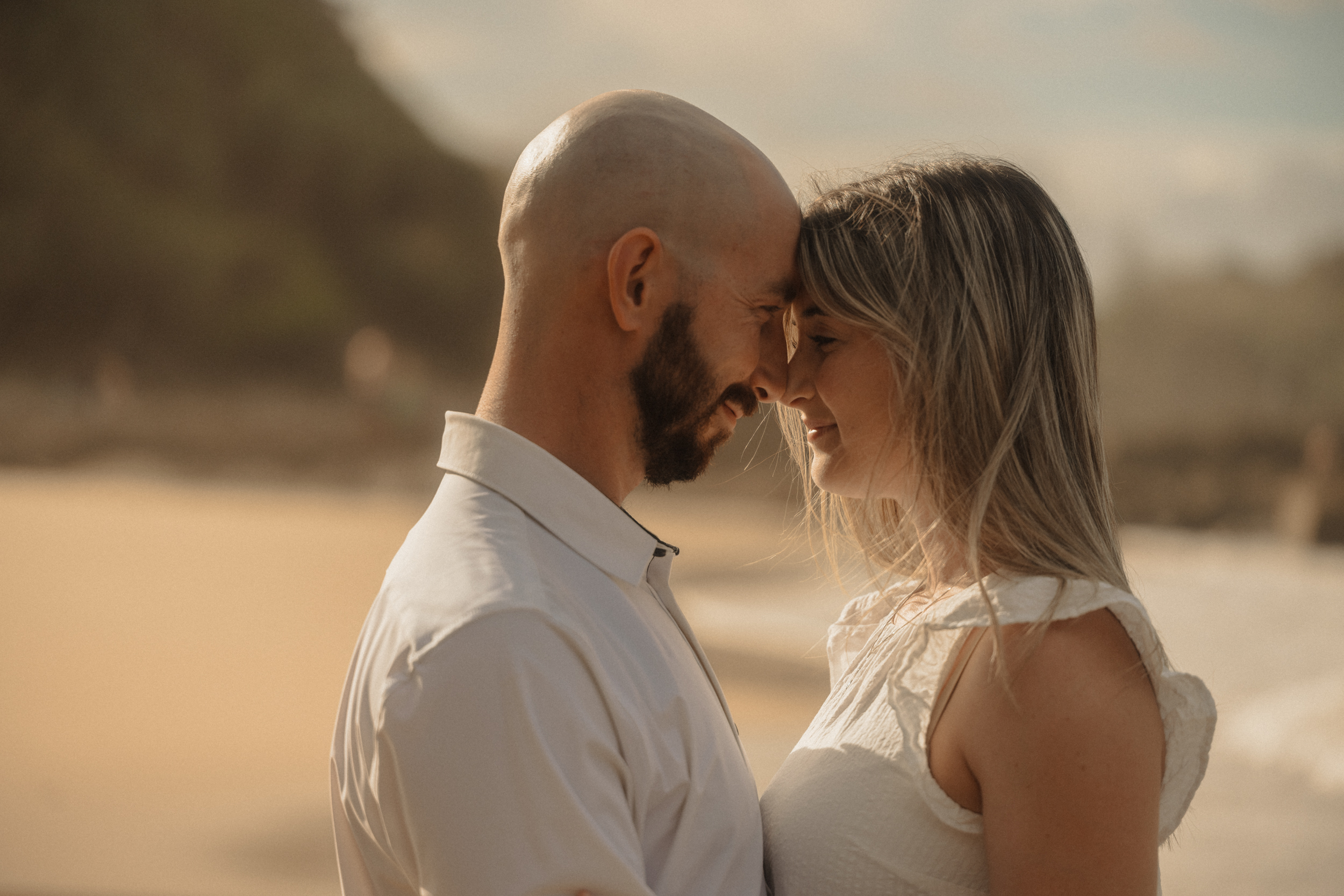 Foreheads together, beach light